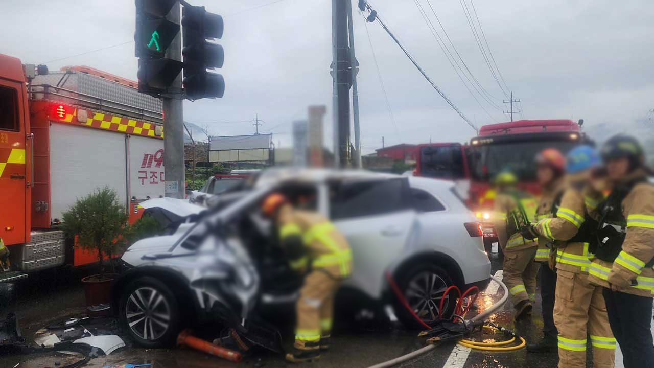 빗길에 미끄러진 SUV 차량, 신호등 들이받아 화재‥2명 사상